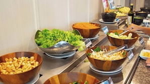 A buffet with various food items in bowls, including salads and other dishes.