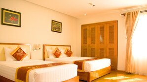A hotel room with two beds, wooden headboards, and a large wardrobe. - Golden Beach Nha Trang Boutique Hotel (Nha Trang)