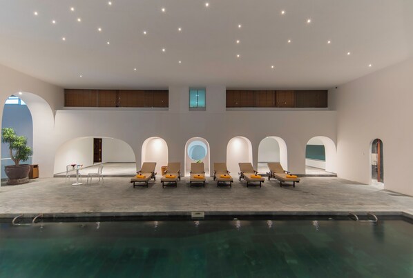 A modern indoor pool area with lounge chairs and a clear view of the sky. - Green World Hotel Nha Trang (Nha Trang)