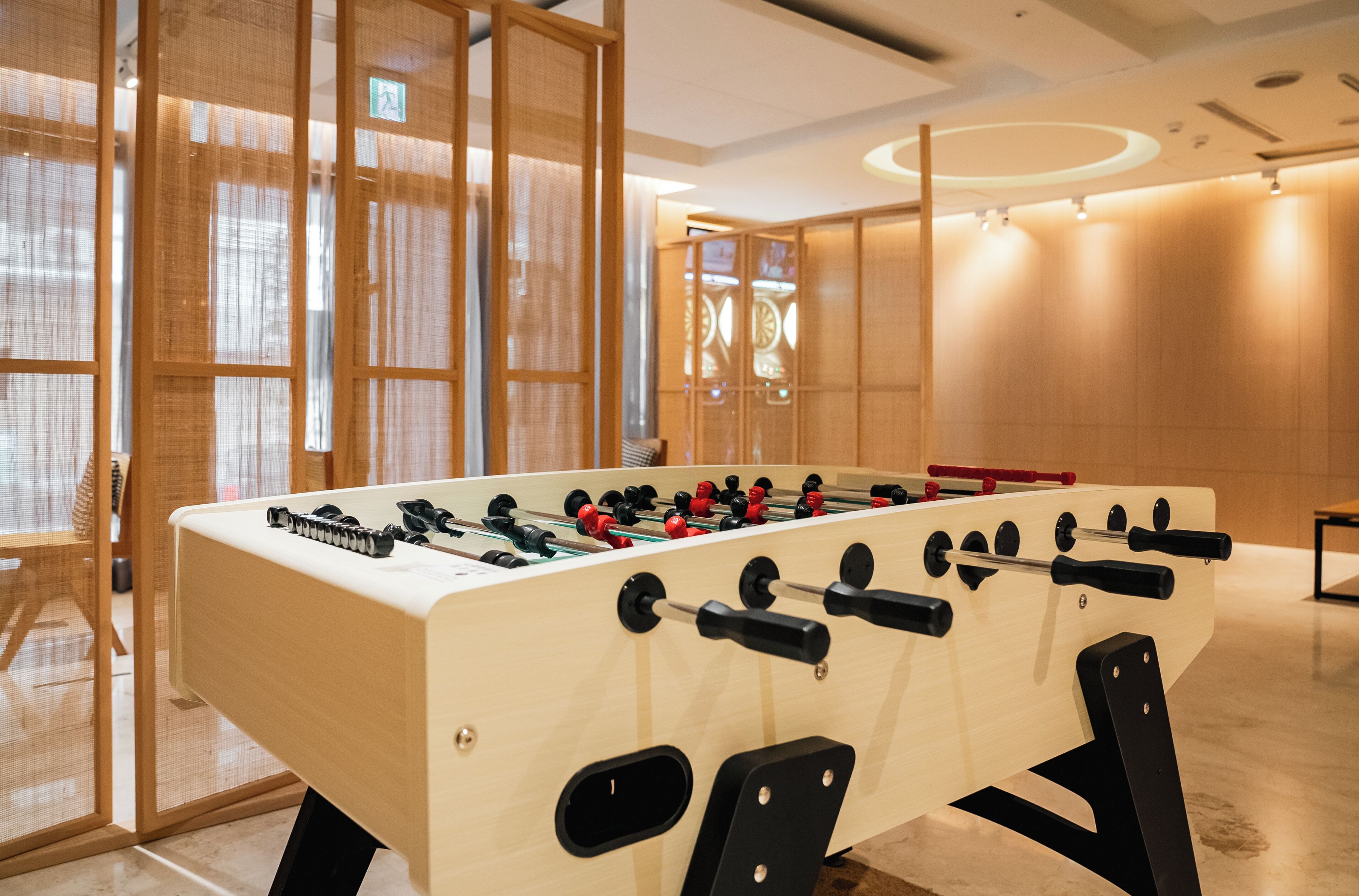 A foosball table in a modern room with wooden partitions and a clean, minimalist design.