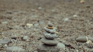 Una pila de piedras sobre una playa pedregosa con el océano al fondo.