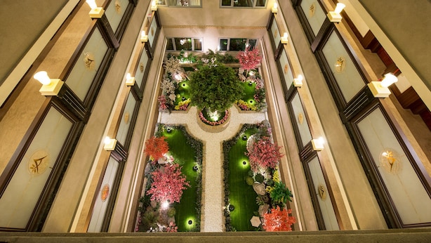 A grand atrium with a central garden, ornate lighting, and a symmetrical design. - Arsma Hotel (Hualien City)