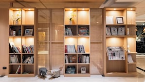 A modern library with bookshelves and decorative plants. - Arsma Hotel (Hualien City)