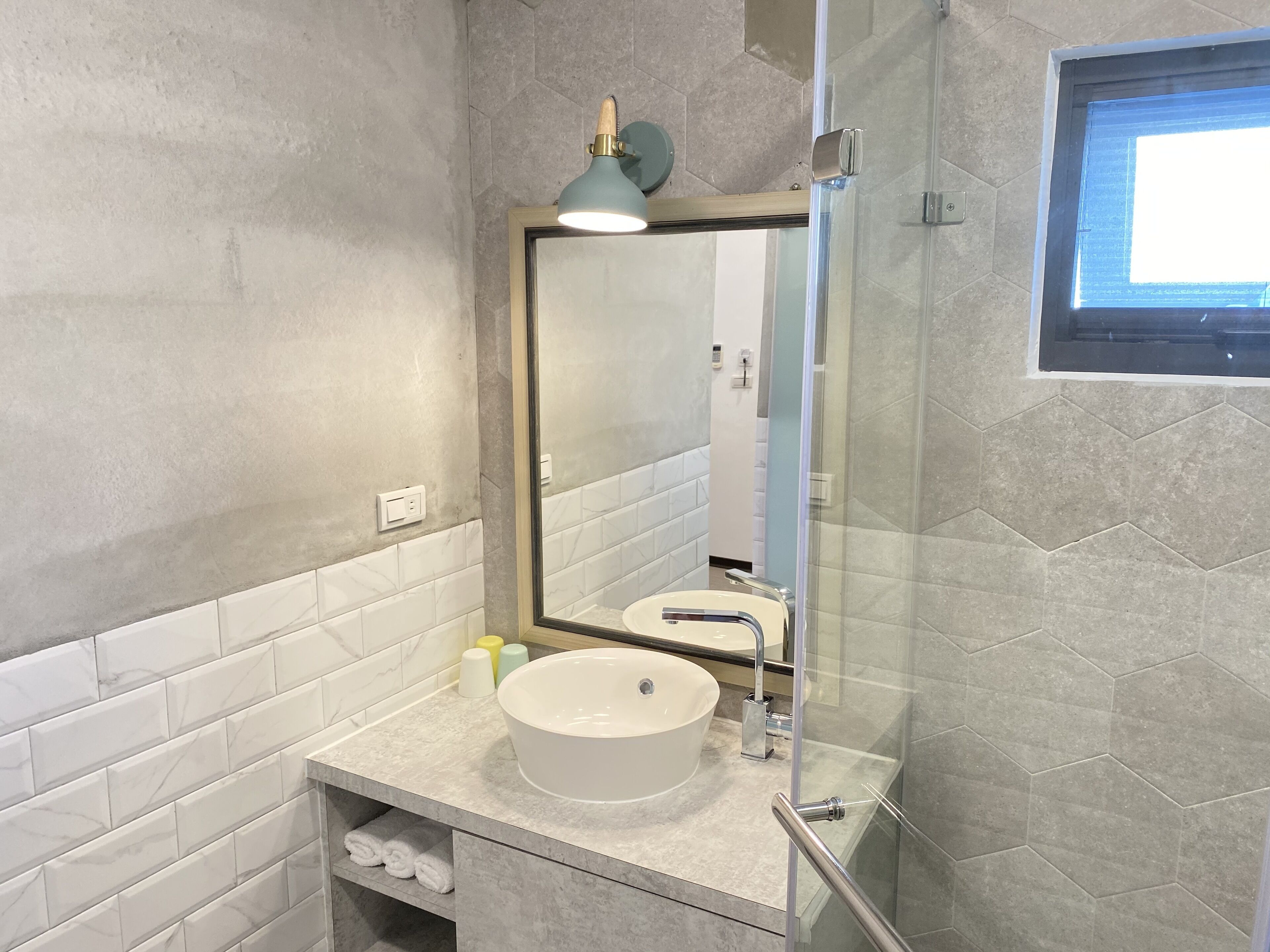 A bathroom with a large mirror, a sink, and a shower area.