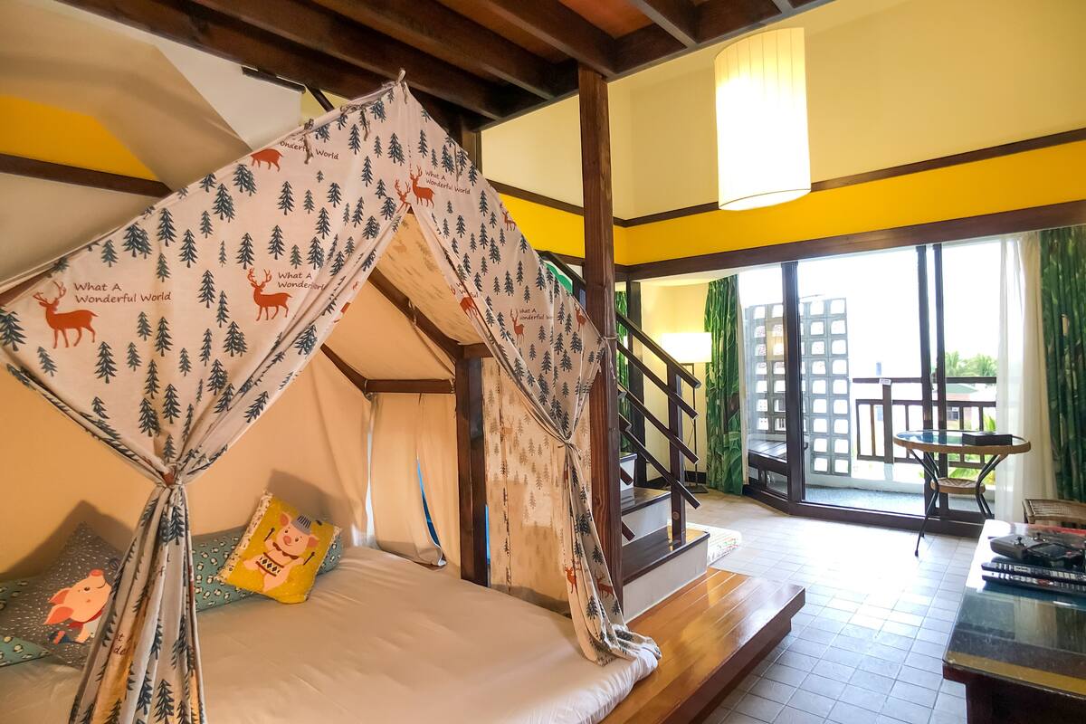 Una habitación acogedora con una cama, una mesita y vistas al exterior.