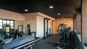 A gym with treadmills, weight machines, and a mirror.