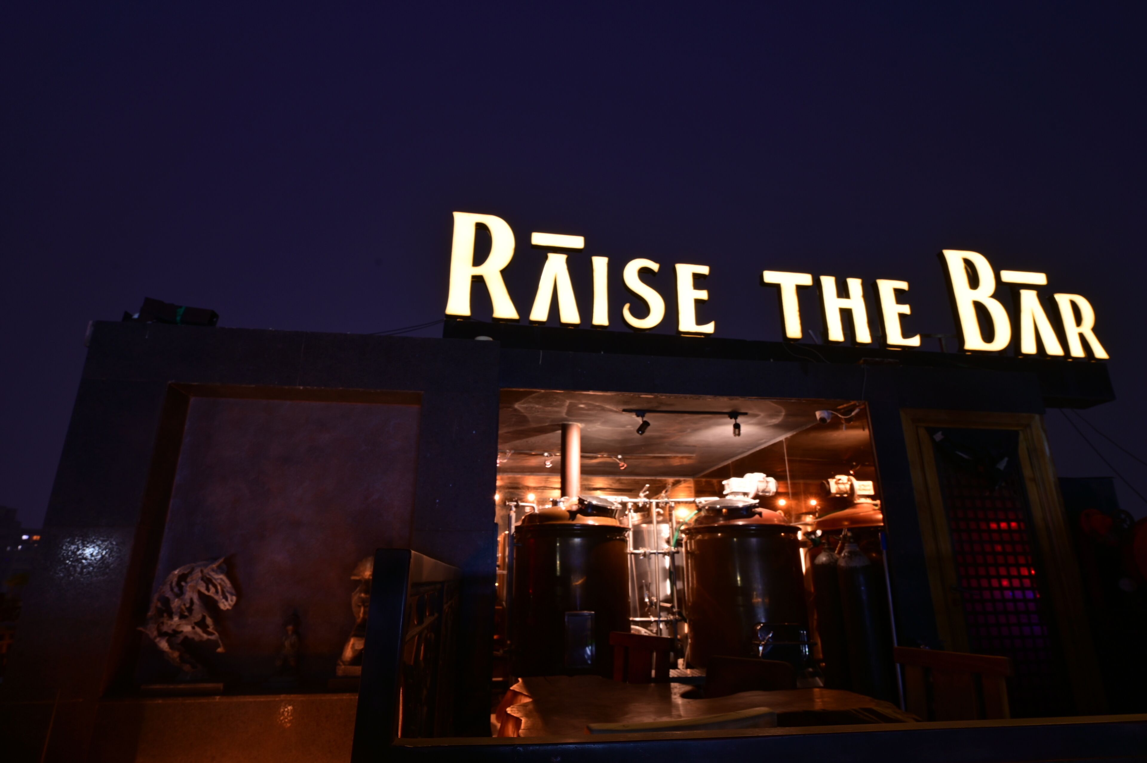 A bar named "Raise the Bar" with a visible interior including large brewing equipment.