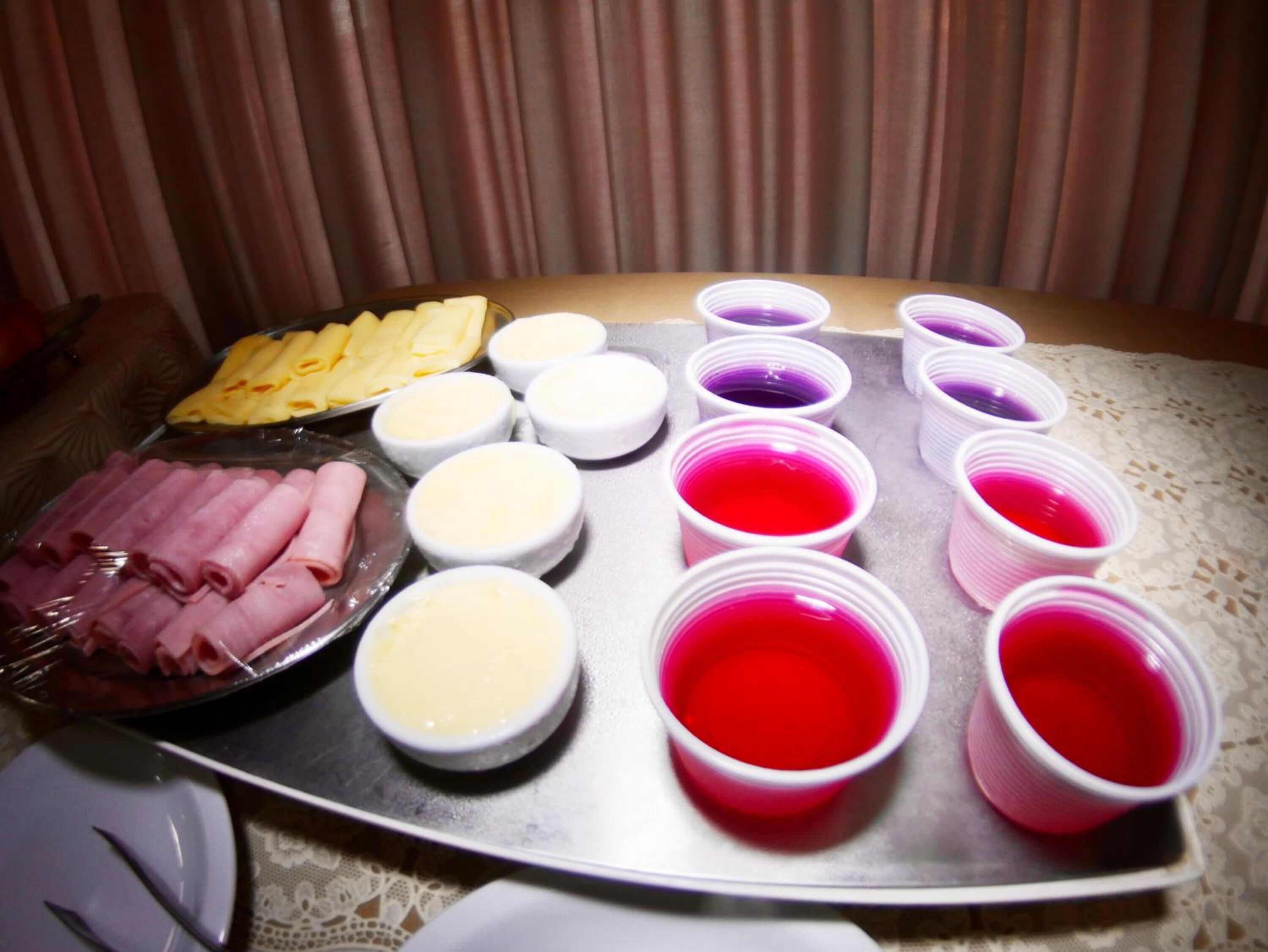 A buffet table with various food items and small containers of sauces.