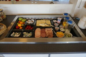 A buffet with various food items including fruits, cheeses, meats, and condiments. - Motel Spar 10 (Viborg)