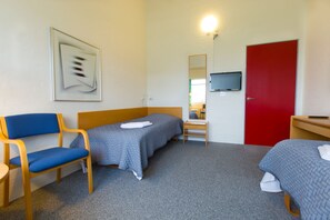 A hotel room with two single beds, a desk with a chair, a TV, and a red door. - Motel Spar 10 (Viborg)