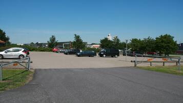 A parking lot with several cars and a building in the background.