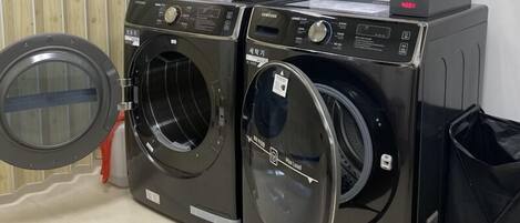 Two front-loading washing machines with control panels and instruction manuals.