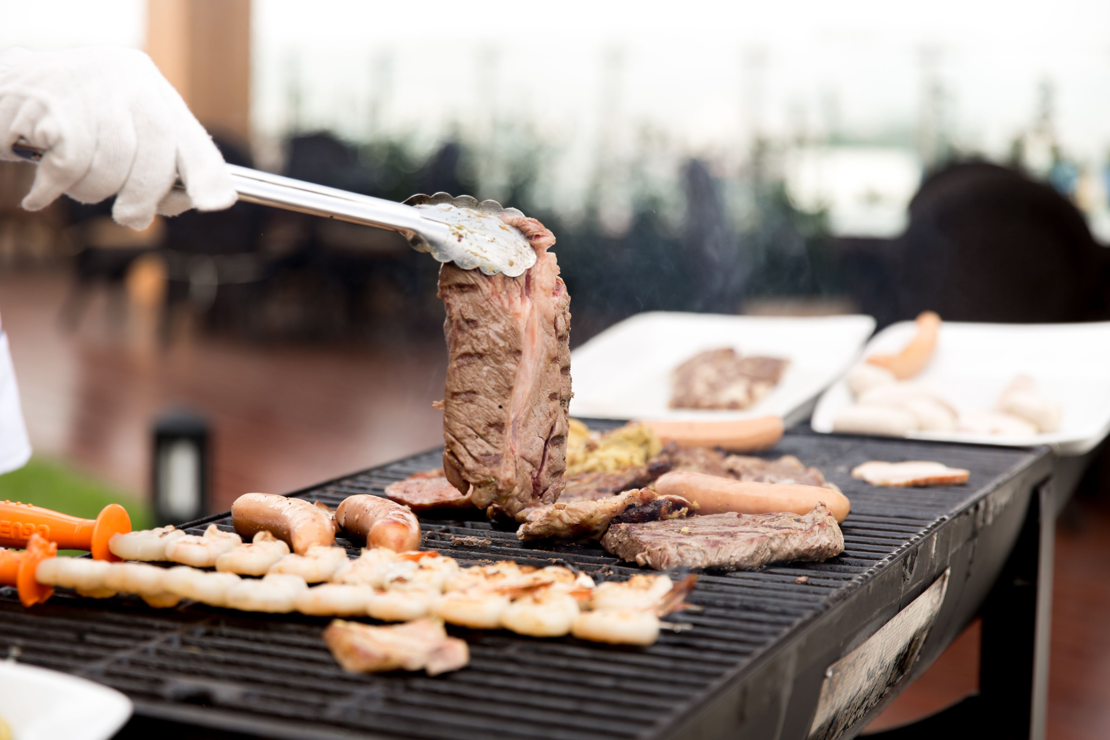 A grill with various meats and vegetables being cooked.