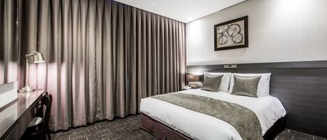 Una habitación de hotel moderna con una cama grande, un escritorio y una silla.