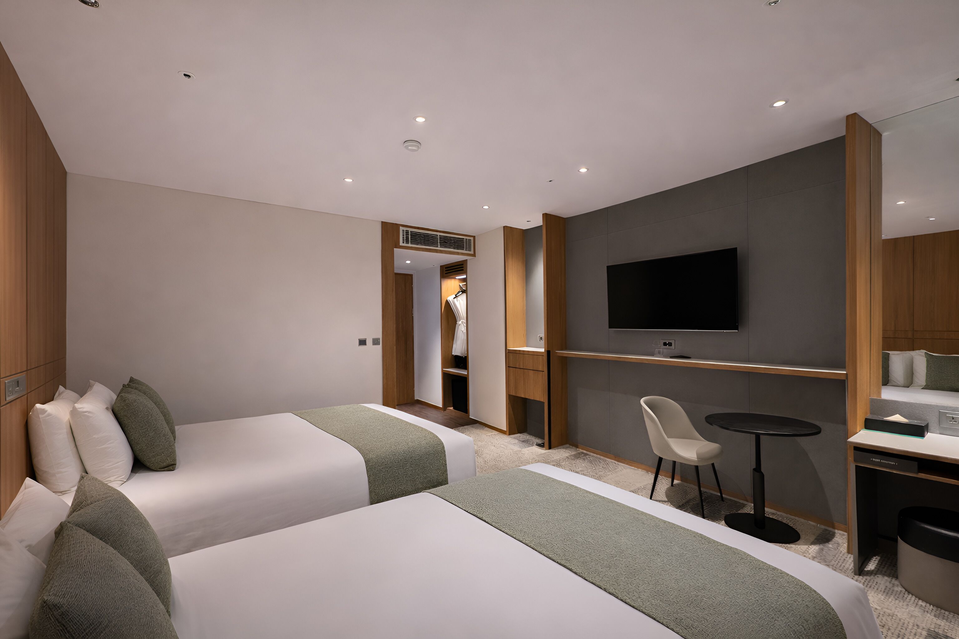 Une chambre d’hôtel avec deux lits, une télévision, un bureau et une chaise.