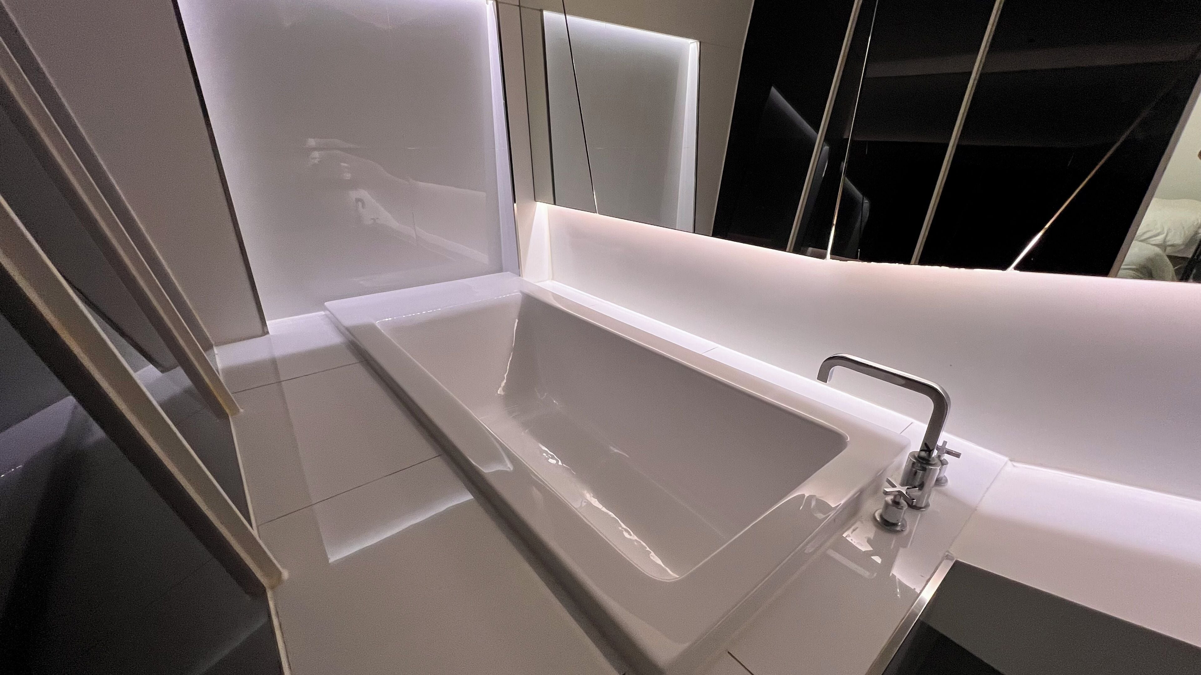 A modern bathroom with a large bathtub, a separate shower area, and a glass-enclosed shower.