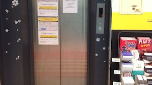 Un ascensor con carteles que muestran el horario de funcionamiento y un mapa del Aeropuerto Internacional de Incheon.