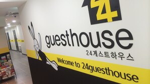 Una pared con un letrero que dice 'guesthouse' y un conejo dibujado.