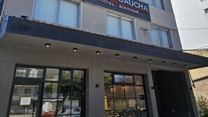 A hotel named Tierra Gaucha with a modern facade, large windows, and a visible entrance. - Tierra Gaucha Hotel Boutique (San Carlos de Bariloche)