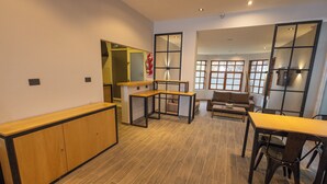 A spacious room with a wooden bench, a dining table with chairs, and a sofa. - Tierra Gaucha Hotel Boutique (San Carlos de Bariloche)