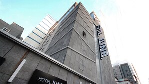 En moderne hotelbygning med et tydeligt skilt, der siger 'HOTEL JUNE'.