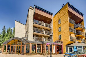 A multi-story building with balconies, a storefront with a sign, and outdoor seating. - Lift House Lodge (Vail)