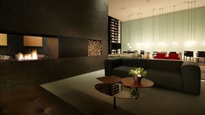 A modern lounge area with a fireplace, seating, and a coffee table. - Shilla Stay Dongtan (Hwaseong)