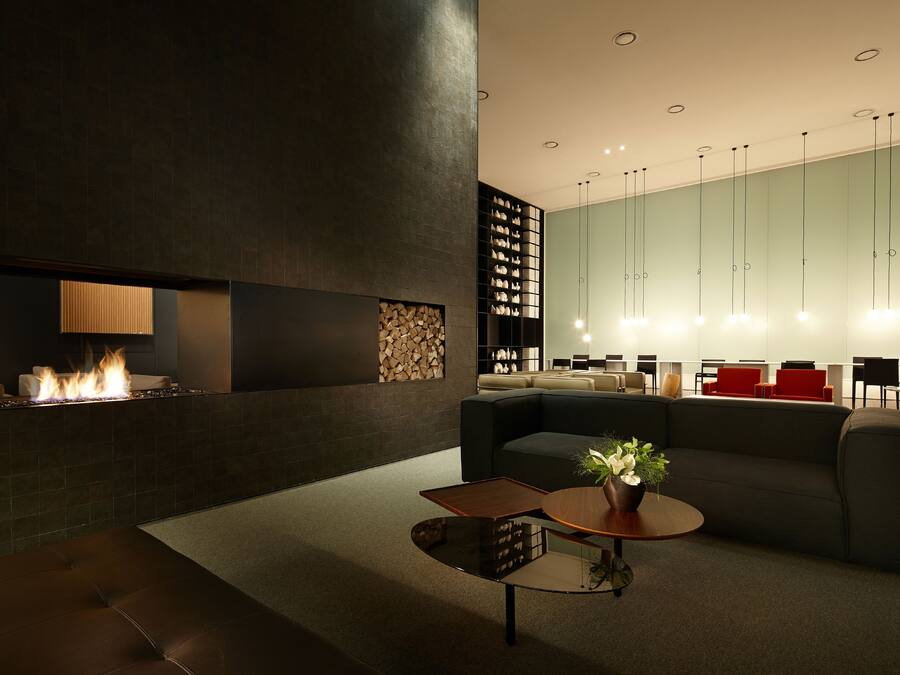 A modern lounge area with a fireplace, seating, and a coffee table.