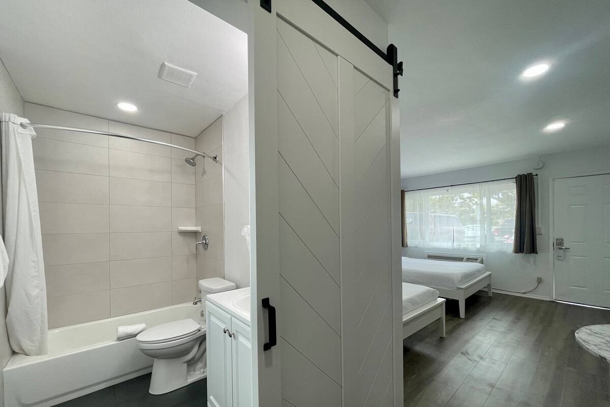 Un baño moderno con bañera, inodoro y ducha.