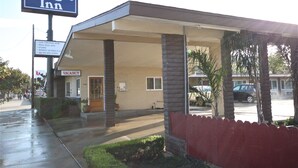 A Budget Inn with a covered outdoor seating area, a 'VACANCY' sign, and a 'Clean Comfortable Rooms' sign. - Budget Inn Lompoc (Lompoc)