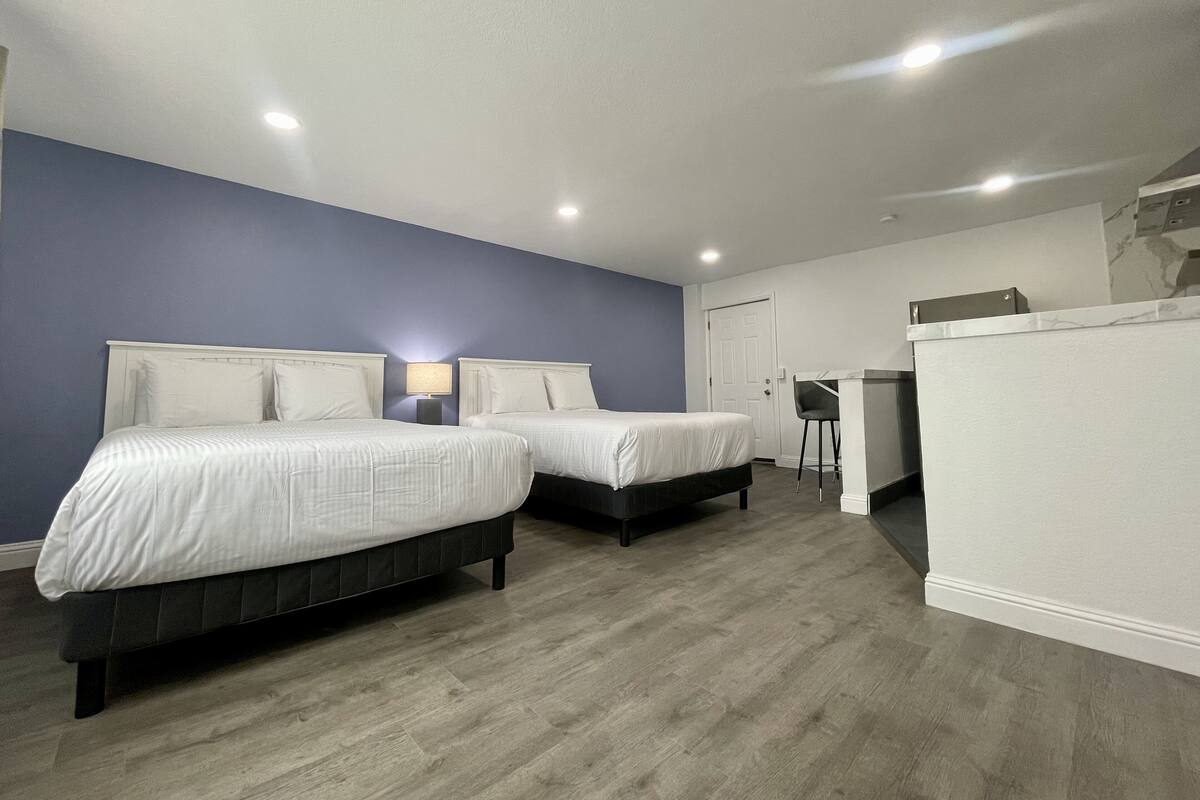 Habitación de hotel con dos camas, un escritorio y una silla.