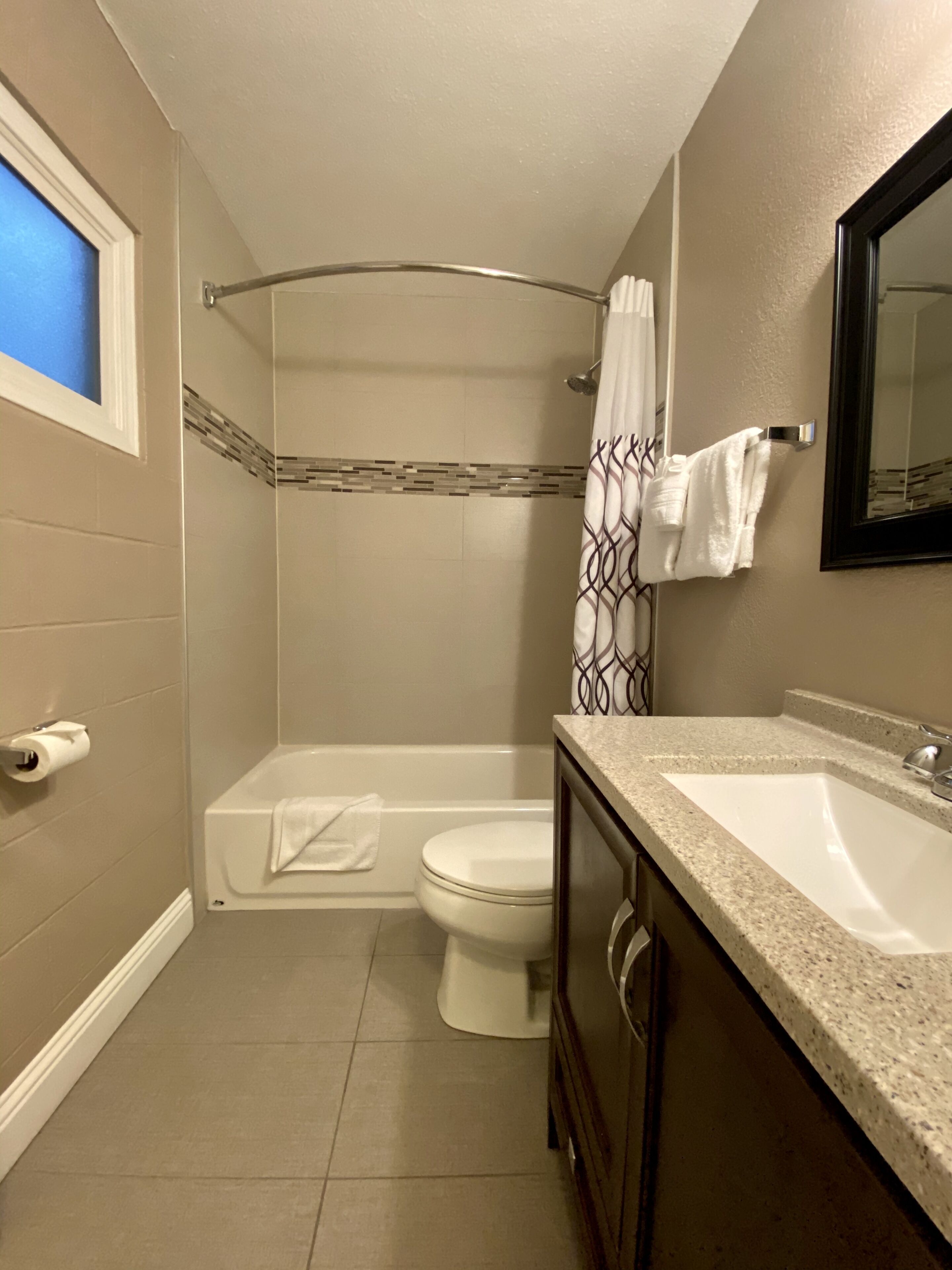 A bathroom with a shower, toilet, and sink.