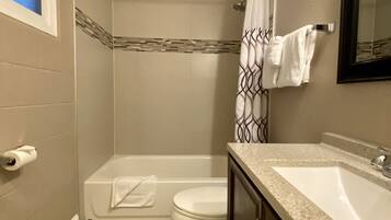 Un baño con ducha, inodoro y lavabo.