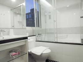 Habitación Deluxe doble | Baño | Cabezal de ducha tipo lluvia, secador de pelo, bidé y toallas