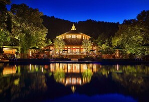 A traditional building with a central dome, surrounded by a reflective pool, and trees in the background.