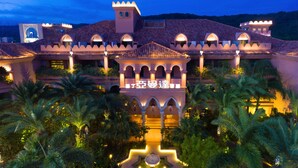 A large, illuminated building with a central courtyard, surrounded by palm trees. - Amanda Hotel Kenting (Hengchun)
