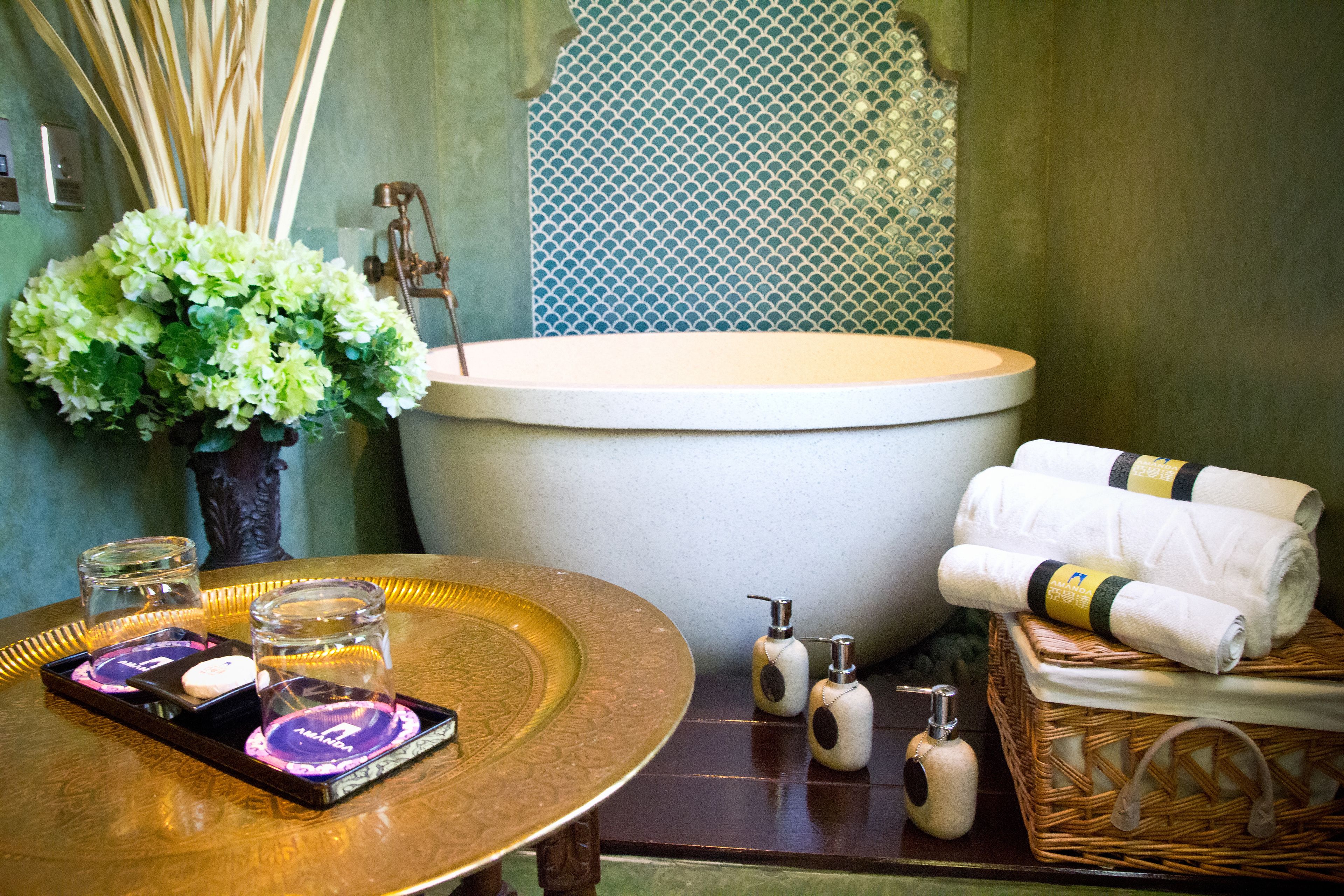 A bathroom with a bathtub, a tray with candles, and toiletries.
