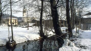A snow-covered landscape with a church and buildings in the background.