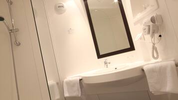A modern bathroom with a glass-enclosed shower, a white sink with a mirror above it, and a toilet.