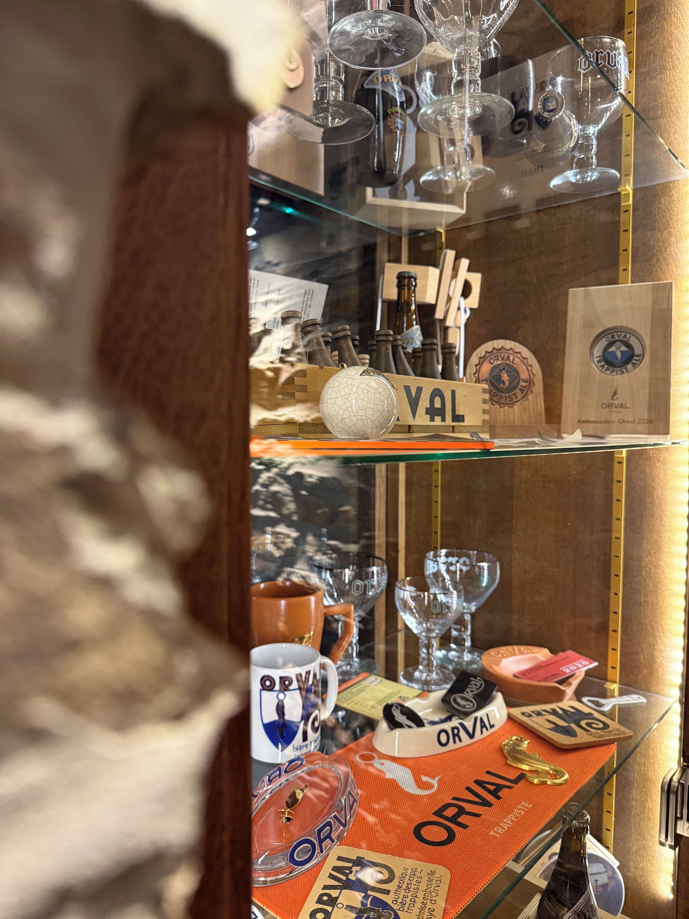 Una exhibición de cristalería y botellas, incluyendo copas de vino, un cáliz de cristal y botellas con etiquetas.