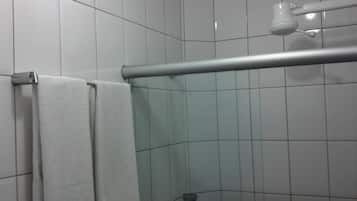 A bathroom with white tiled walls, a shower area, and a towel rack.