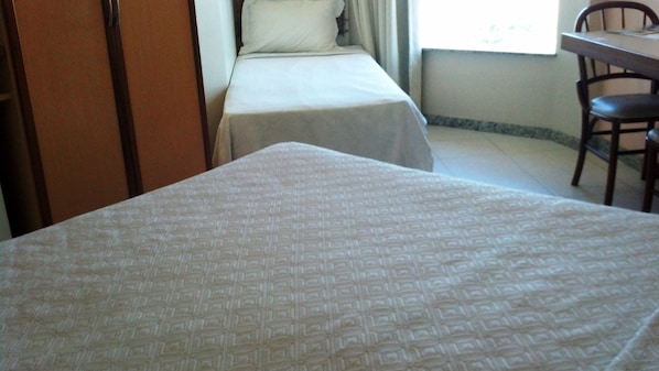 Habitación de hotel con dos camas, un escritorio y una silla.