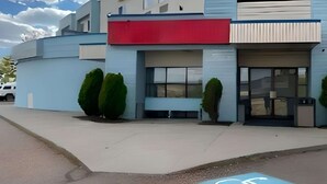 A modern building with a red and blue facade, a wheelchair-accessible parking space, and neatly trimmed bushes. - Econo Lodge Inn & Suites Jackpot near Casino (Jackpot)
