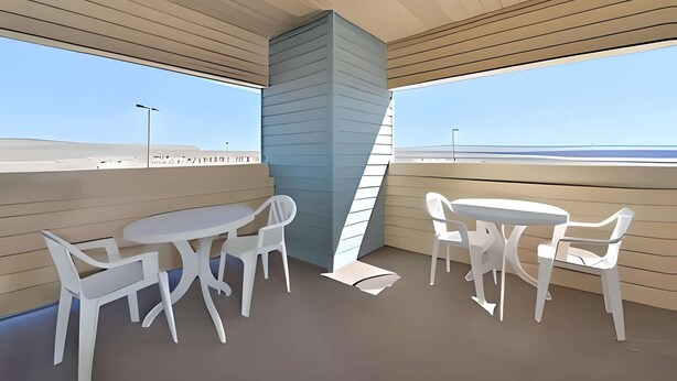 A modern interior with a wooden ceiling, a blue accent wall, and a view of the beach. There are white tables and chairs arranged for dining. - Econo Lodge Inn & Suites Jackpot near Casino (Jackpot)