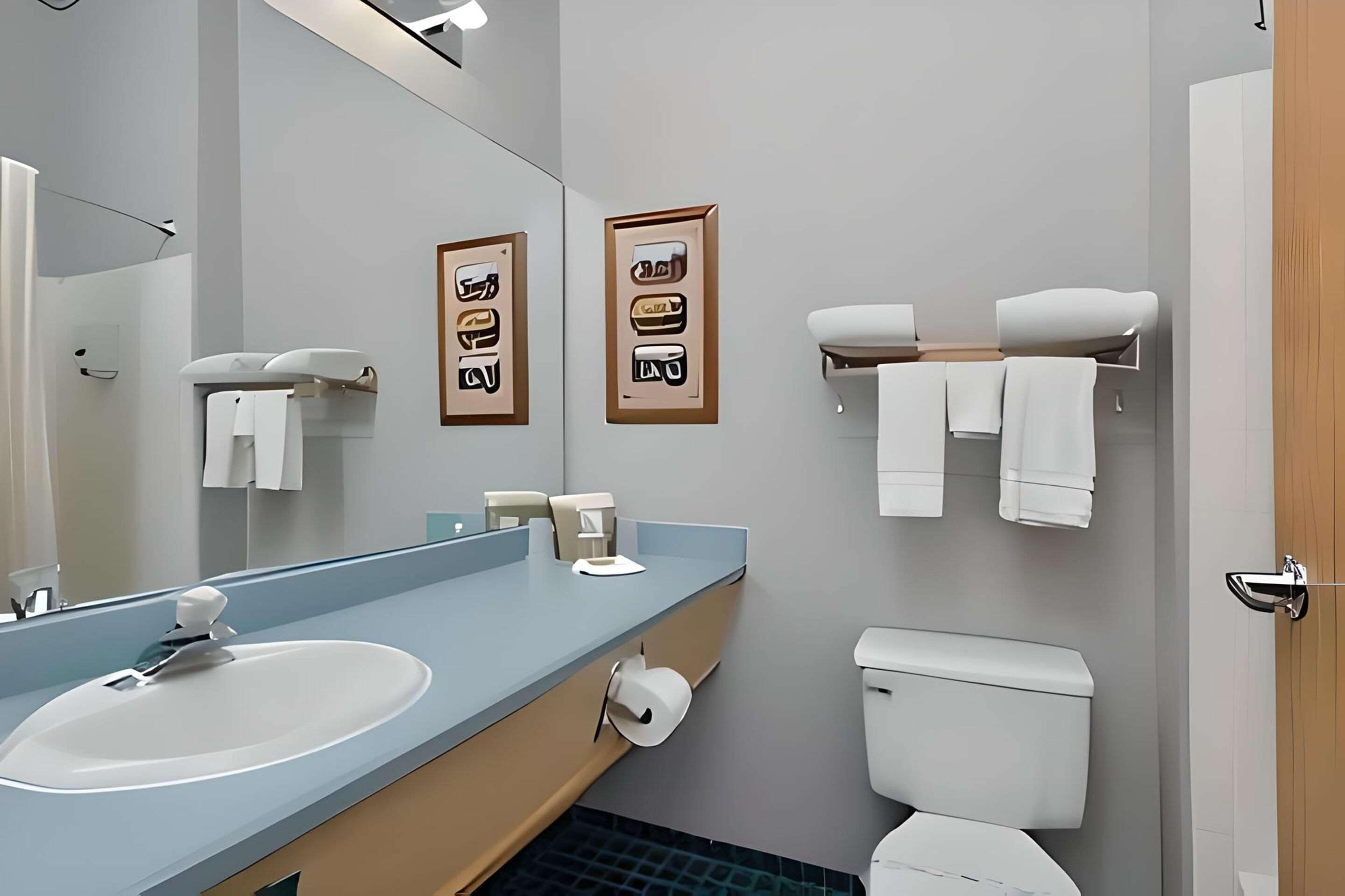A modern bathroom with a sink, mirror, toilet, and towel rack.