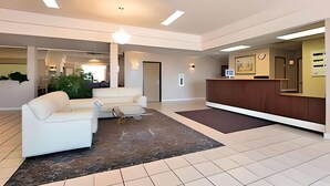 A modern lobby with a reception desk, a white sofa, and a coffee table. - Econo Lodge Inn & Suites Jackpot near Casino (Jackpot)