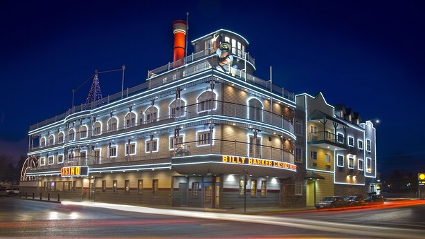 A large, multi-story building with a prominent casino sign, multiple balconies, and a distinctive red chimney. - Billy Barker Casino Hotel (Quesnel)