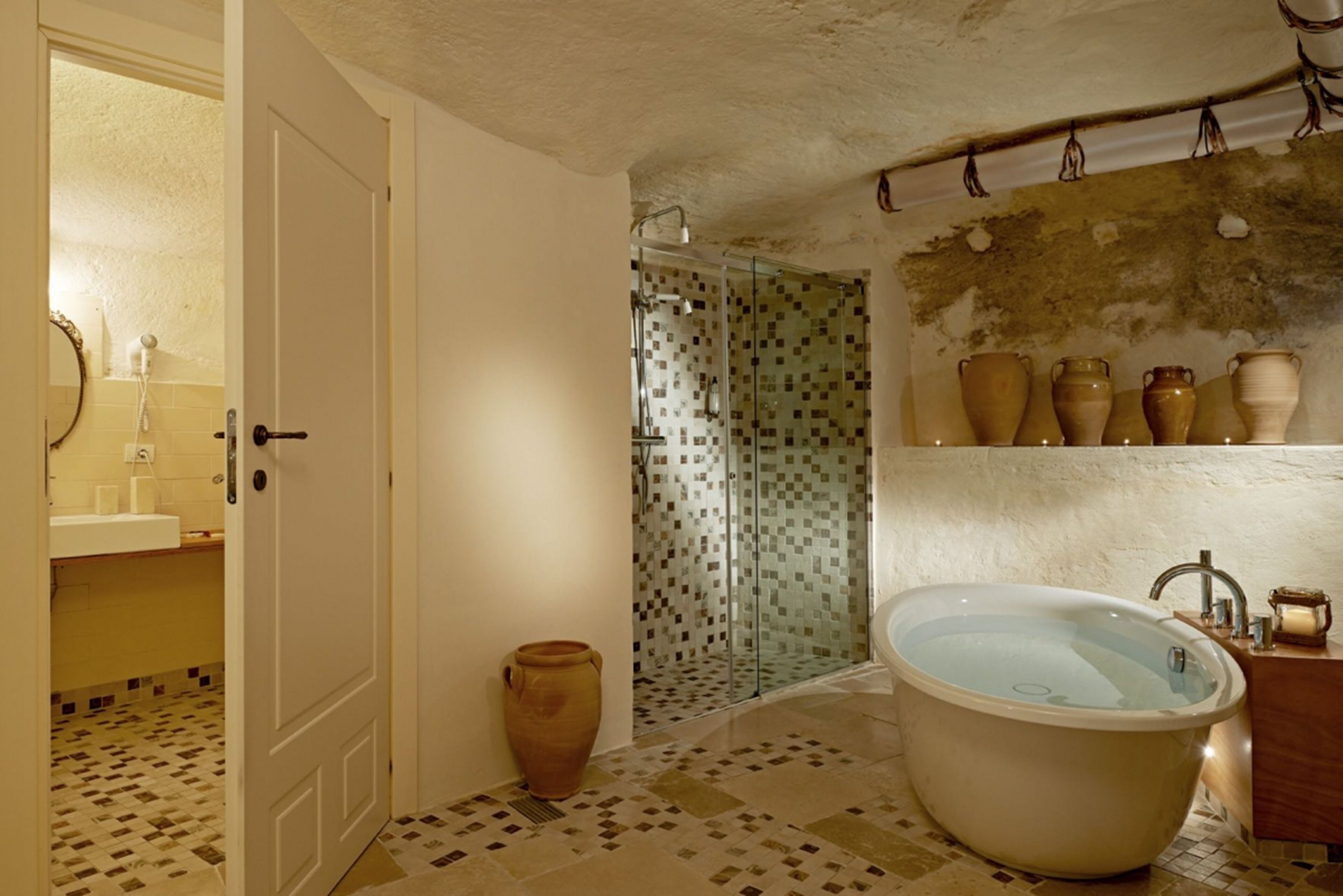 Un baño con bañera, ducha y suelo de baldosas.