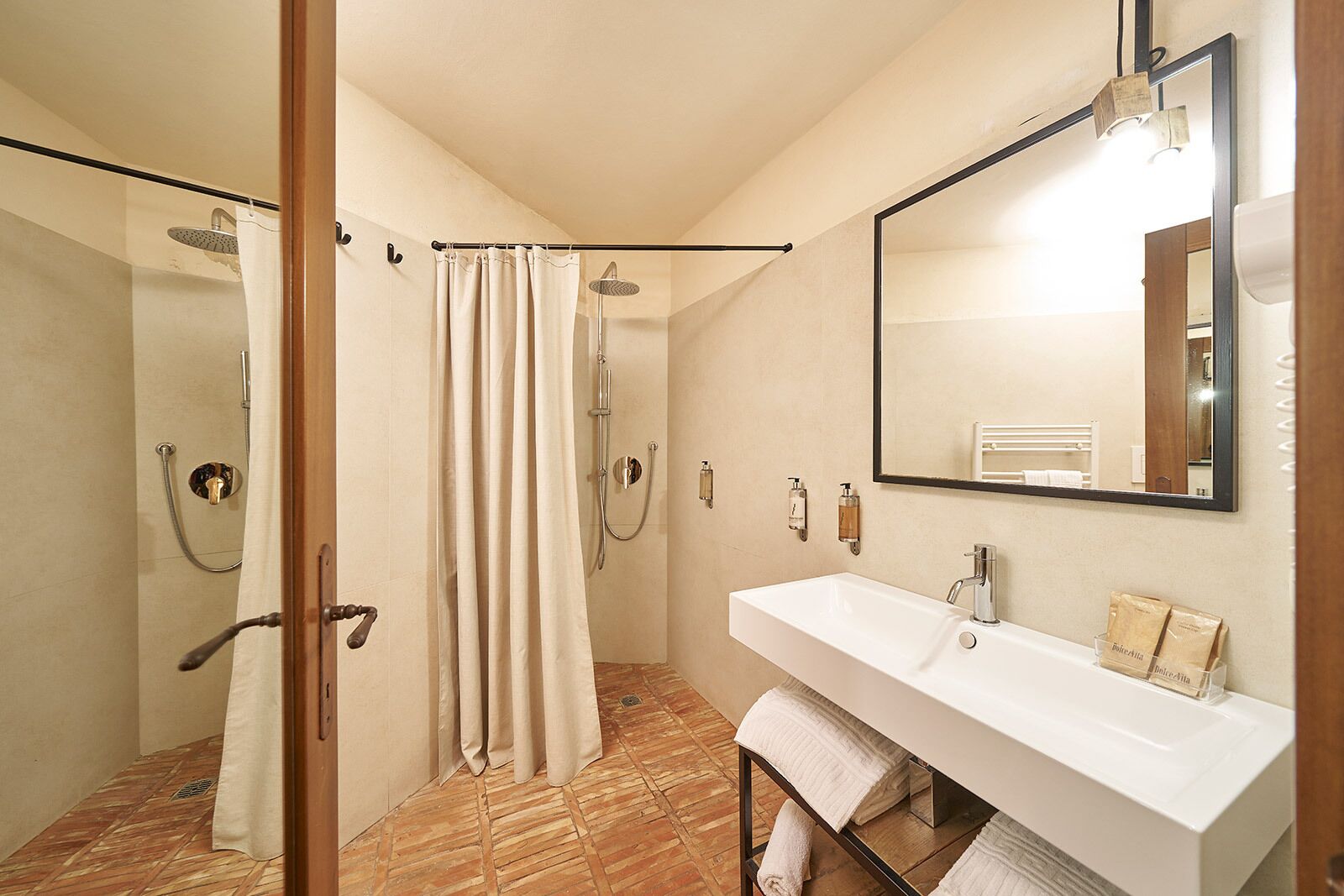 A bathroom with a shower, a sink, a mirror, and a towel rack.