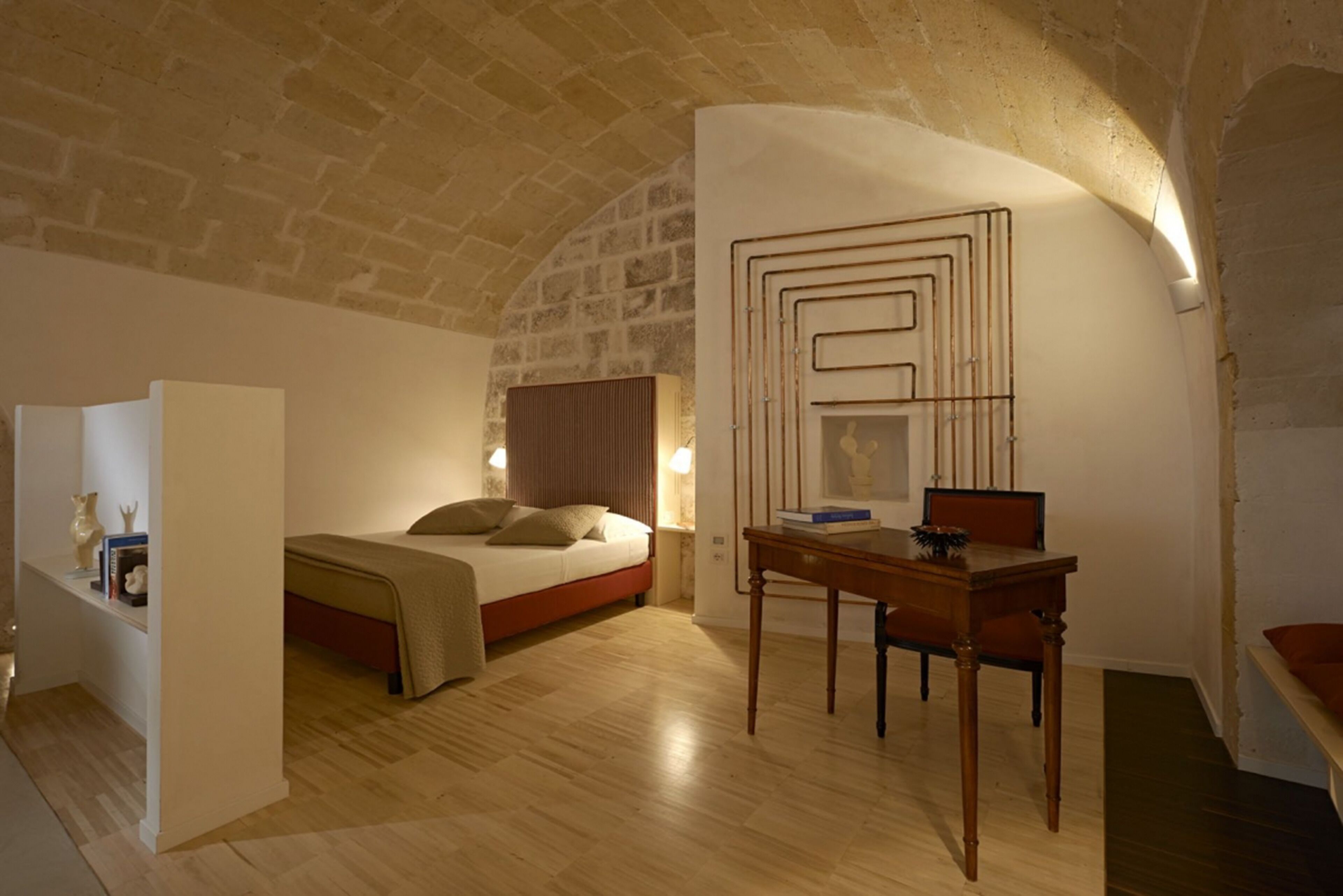 A bedroom with a wooden bed, a desk, and a wall-mounted artwork.